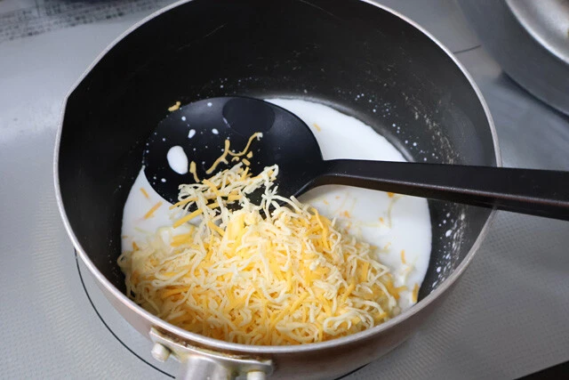 (1)溶かす! まずはチーズソースを準備。鍋に牛乳と片栗粉を入れてしっかり混ぜ、チーズを入れて中火にかけ、よくかき混ぜながら溶かしていく。全体にとろみがついてきたら火を止める