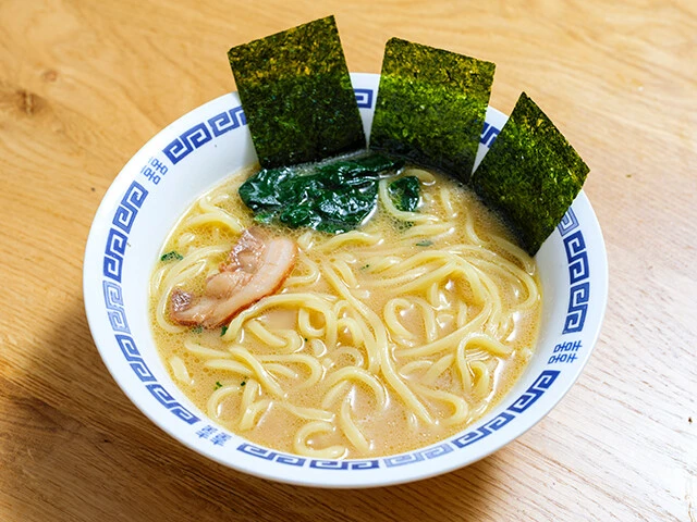 濃厚な豚骨醤油スープをそのまま冷凍し、味の厚みが圧倒的。鶏油・豚骨・醤油のバランスも絶妙。吉村家と壱六家の中間を意識した、誰からも好まれる真ん中な仕上がり