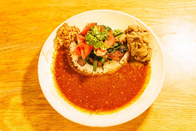 ルーローホルモンと麹納豆をのせたトッピングセット（1650円）もおすすめ。ルーローホルモンは「もつ煮込み台湾風」といった味わいで、八角の香りがするとろとろのもつ。麹納豆はほんのり甘く、シビれのあるルーをまろやかにしてくれる