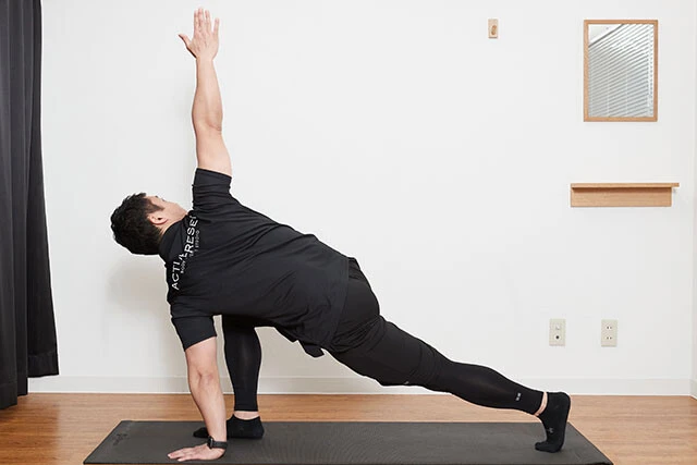 ストレッチ④つま先についた手を、できるだけ体を大きく回転させながら上に持っていく