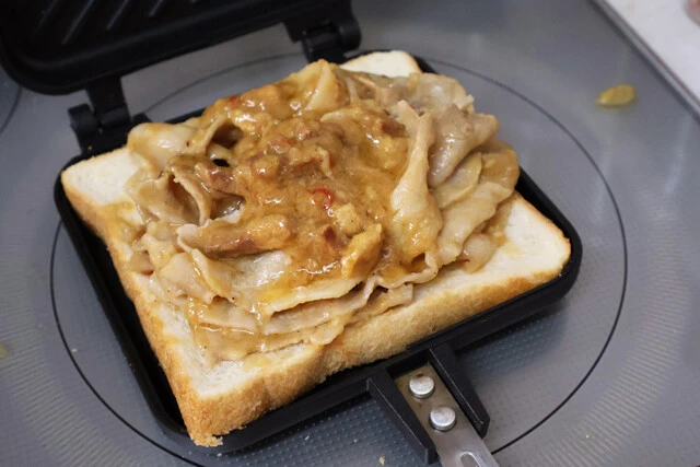 (3)挟む! (2)のパンをホットサンドメーカーに置き、その上に(1)の肉を重ねるようにして並べたらもう1枚パンをのせる。ニンニクをマシマシにしたい人はここで刻みニンニクを!