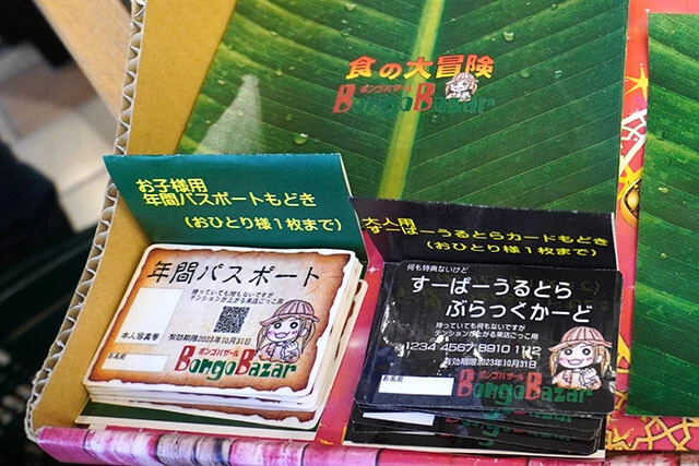 「食の大冒険」と書かれたギフト用包装紙と、「夢の国」の年パスとブラックカード