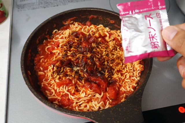 (3)ソース! 麺がしっかりほぐれたらトマトを全体になじませ、粉末ソースをかけてよく混ぜよう。さらに加熱して水分を飛ばしたり、麺を軽く焦がしたりすると一段とおいしくなる