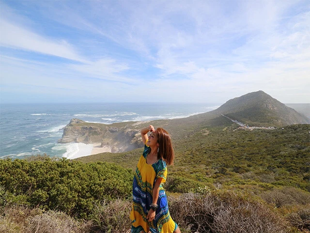 大海原から吹く風に向かって立つ旅人