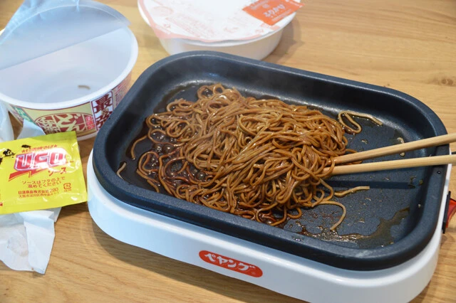 (1)焼きそば! 最強どん兵衛の麺を焼きペヤングメーカーに移し、水を麺の高さの3分の1程度まで入れて加熱。ほぐれたらU.F.O.のソースを入れる。高温で仕上げる焼きそばは抜群にウマい!