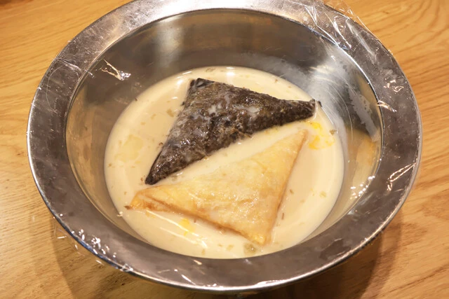 (2)漬ける! 三角チョコパイを(1)の中に入れ、ラップをして冷蔵庫に入れてひと晩漬け込む。ボウルが小さくてうまく漬からない場合は途中でひっくり返し、両面を交互に浸すとよい