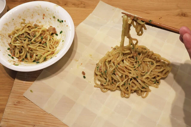 (1)作る! ワンタンの皮の端に水を塗り、ワンタン同士をくっつけて6×6サイズの特大皮を作る。その中央にレンチンした台湾まぜそばをのせたら三角形に折り、ワンタンの口を閉じよう