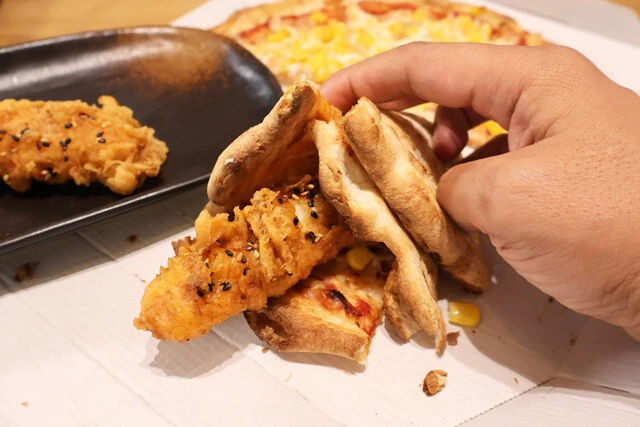 (2)包む! 「たっぷりマヨコーンピザ」を半分のサイズにカットし、「にんにくクリスピー」をクレープのように包もう。ピザはテイクアウト時にカットしないよう頼んでおくと作りやすい