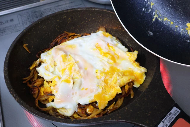(3)卵! さらに軽く黄身を潰した目玉焼きを作り、焼き上がったら(2)の上から全体を覆うようにしてのせよう。ナポリタンをたくさん焼いた場合は卵の量も増やすこと