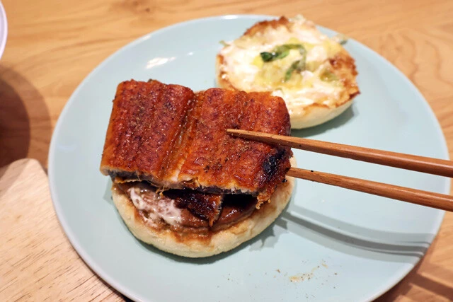 (2)挟む! てりやきマフィンを開き、ポークパティの上にうなぎを重ね、山椒をたっぷり振りかける。あとは再びマフィンをのせ、包み紙に戻して豪快にかぶりつこう。朝から贅沢なウマさ!