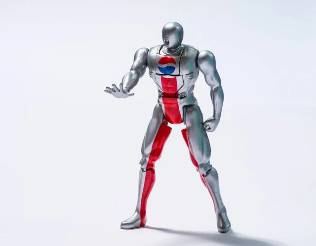初期ペプシマンのアクションフィギュア。足を握ると頭部が変化する