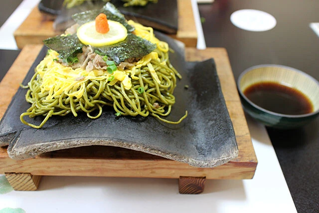 山口県の名物グルメ「瓦そば」。1962年に下関市川棚温泉にある「瓦そば たかせ」が開発したという。瓦の上にのった茶そばをつゆにつけて食べる