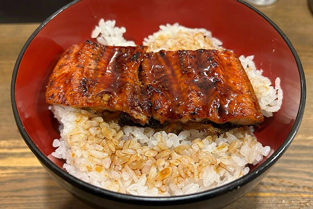 【宇奈とと】「価格破壊系うな丼のパイオニア」うなぎの脂が少なめで好みが分かれそうだが、価格を踏まえれば十分な満足感。硬めに炊かれた米との相性がいい。おつまみメニューも充実しているので、晩酌使いにも適していそう。卓上に柴漬けがあるのもありがたい（注文したメニュー　うな丼...590円）