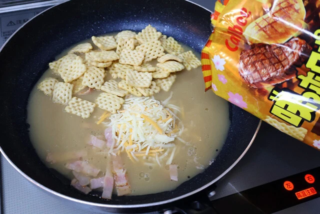 (1)ソース! フライパンにサラダ油を引き、細かく切ったベーコンをしっかり炒めたら天下一品の鍋スープを入れる。スープが煮立ったら続いてとろけるチーズとサッポロポテトも入れよう