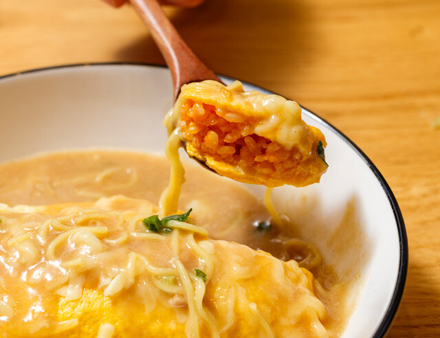とろけるチーズをのせたオムライスに天一のスープをぶっかけ。やや尖った味わいだが、ホットミルクの少量追加で完璧に整った！