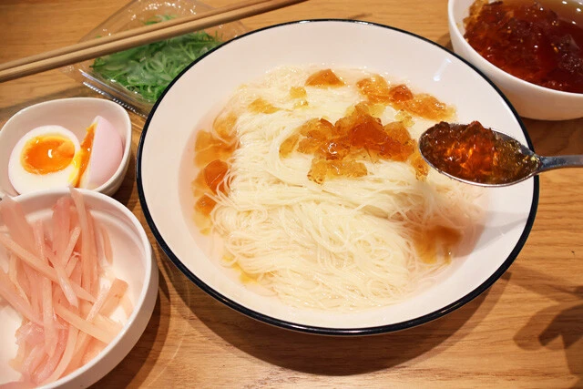 (4)盛りつけ! 冷やしたそうめんを食器に盛り、(1)の残り汁をぶっかけ。さらにほぐした(2)を適量盛りつけ、新生姜の細切りやお好みの薬味、味玉を盛りつければ完成。よく混ぜて食べよう!