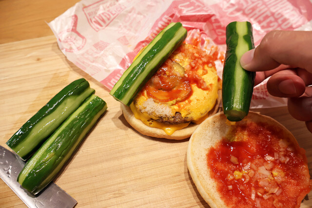 （３）挟む！ダブルチーズバーガーを開き、お好みのサイズに切った（２）を挟む。食べるときは包み紙に戻してバリボリと豪快にかぶりつこう。ピクルス好きなら大満足間違いなし！