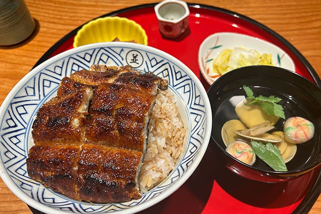 【炭焼 うな富士】《店舗数》…8店舗　《焼き方》…関西風　《出店エリア》…東京・☆愛知・京都　《漬物》…○　《椀物》…肝吸い付き「ミシュラン掲載店が東京に進出！」うな丼に漬物のほか、キュウリと昆布とキャベツのあえ物、小鉢、肝吸い、刻みわさびがつく充実の構成。タレの風味も文句なし。ちなみに、上にのった2切れだけでなく、ご飯の中にもう1切れ埋まっていた（注文したメニューうなぎ丼…5100円）