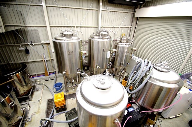 広めのスペースに大きなタンクが並ぶ醸造所内