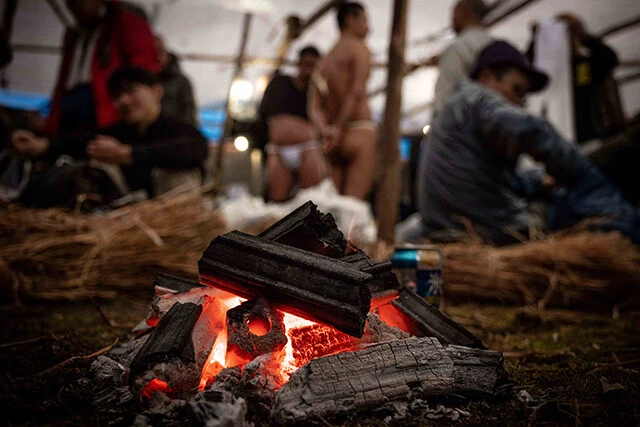 裸の男たちは、木とわらで作られた仮設の小屋で待機。施設内の各所に設置されている炭のたき火で暖を取る