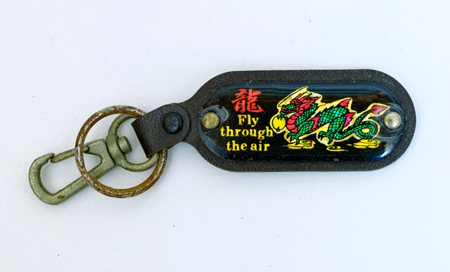 定番のドラゴンキーホルダー。ドラゴンの裏ボタン。こちらは観光地の土産店で販売された製品で、大きな台紙の裏側に使用法の説明を表記。普段は授業をエスケープするヤンキーも、仲間思いな性質から修学旅行などには積極的に参加しました