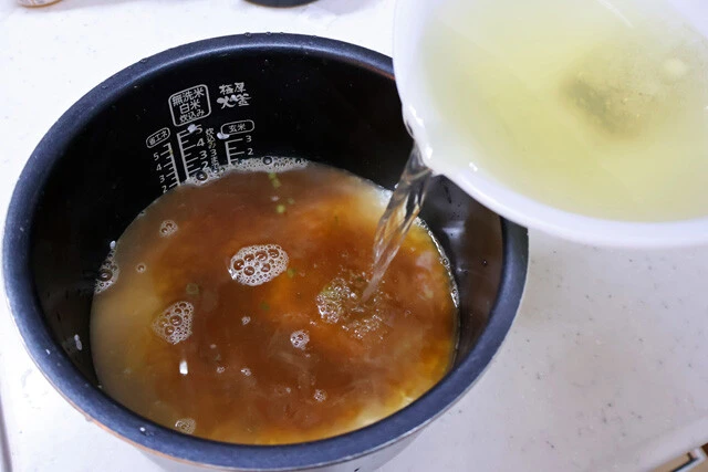 (3)入れる! 炊飯器に研いだ米を入れ、(1)を全量入れる。スープだけでは米2合を炊くには足りないので、不足分を補う煮干しブーストの(2)も入れ、全体をよくかき混ぜよう