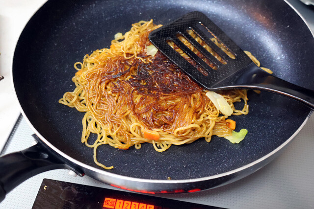 フライパンに押しつけるように焼いて焦げ目をつけたソース焼きそばに、永谷園の広東風かに玉を作ってのせる。味の濃さはあんの量で調整。パリパリのソース麺が激ウマ！