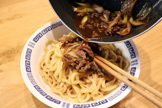 (3)ぶっかけ! (2)を丼に移したら、アツアツの状態の(1)を豪快に全量ぶっかけよう。今回は牛肉とネギしか使っていないが、すき焼きに合う具材ならなんでもOK。お好みのものを追加しよう