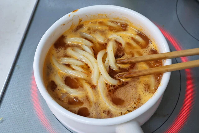 (3)煮込む! さらに丸亀製麺のうどんを好きなだけ投入し、麺がスープをしっかり吸収するまで5~10分くらいグツグツと煮込み続けよう。この間もこまめにかき混ぜることを忘れずに!