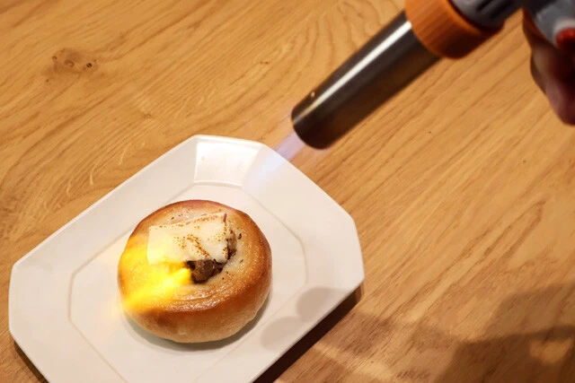 (4)バーナー! ビストロまんはこんがり焦がした香ばしさが重要。とはいえ、トースターなどで焼くと生地がパサパサになってしまう。仕上げはガスバーナーを使ってチーズに焦げ目をつけよう