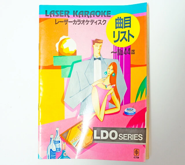 レーザーカラオケの目次本。どのディスクの何曲目かという情報から人が探して再生する時代から、曲数は限られるがオートチェンジャーをリモコン操作できる時代になった