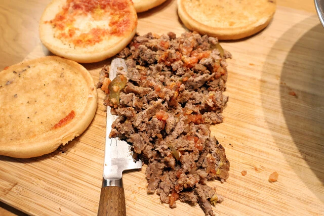 （２）刻む！　ハンバーガーを解体し、ビーフパティ、ピクルス、オニオンを細かく刻む。できたら（１）のボウルに投入し、混ぜ合わせた後、手で握ってコロッケの形に固めよう