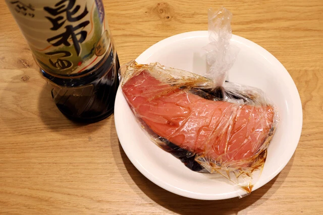 (1)漬ける! ブロック状の刺し身用マグロをビニール袋に入れ、全体が浸るくらいまでめんつゆを注ぐ。15分以上を目安に漬け込もう。めんつゆと一緒にわさびチューブを入れるのもアリだ