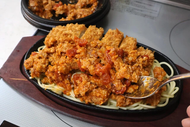(4)仕上げ! 鉄板を加熱し、スパゲティがパチパチと音を立て始めたら(1)で作ったミートソースを全体にかければ完成。ワイルドすぎて少し食べにくいがウマさはガチ! ご賞味あれ!
