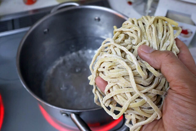 (2)ゆでる! (1)の手順と並行して大きめの鍋で極太麺をゆでる。ゆで上がったらザルにあけ、熱湯をかけて麺のぬめりを取ろう。今回はヤオコーで売っているG系極太麺(岩崎食品)を使用
