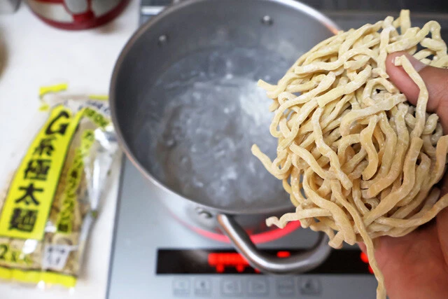 （３）ゆでる！　鍋にお湯を沸かし、スーパーなどで調達した二郎系極太麺をゆでる。今回は岩崎食品のG系極太麺を使用。ゆで上がったらザルにあけ、熱湯をかけてぬめりを取ろう