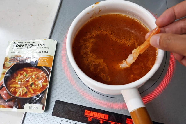 (2)スープ! 無印良品のスープパスタの素に水を入れて鍋で加熱する。中には具材が入っているので焦がさないようにしっかりかき混ぜながら温め、沸騰したら(1)のエビを入れよう