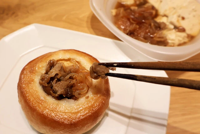 (2)入れる! ビストロまんの空洞に肉豆腐を詰め込む。肉だけでなく豆腐やしらたきも入れよう。今回はファミマの「味しみ肉豆腐」を使ったが、どこの肉豆腐、すき焼きでも代用可能だ