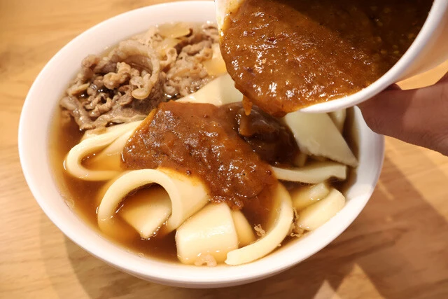 (3)カレー! 麺をゆで終えたらつゆごと丼に移し、レンチンで温めたカレーをたっぷりかければ完成。もったいない気もするがよく混ぜて食べよう。スパイスカレーと牛肉が見事に一体化!