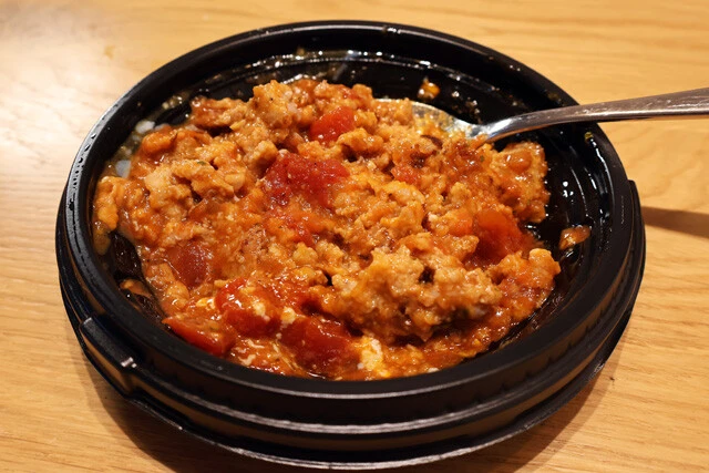 (1)潰す! うまトマハンバーグの温玉を取り出したら、スプーンなどを使ってハンバーグ全体をグニグニと潰し、うまトマソースとよく混ぜてミートソースにしよう(温玉は不使用)