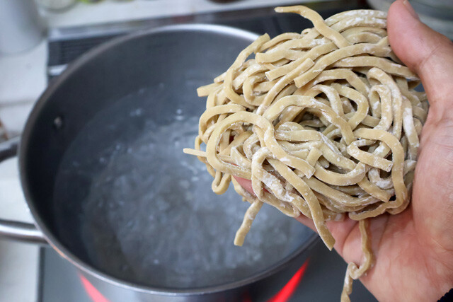 （１）ゆでる！　鍋にたっぷりのお湯を沸騰させ、豚ラーメン用極太麺をゆでる。ゆで終えたら麺をざるに上げて水気を切ろう。別で熱湯を用意できるなら麺にかけ、ぬめり取りできるとなおよし