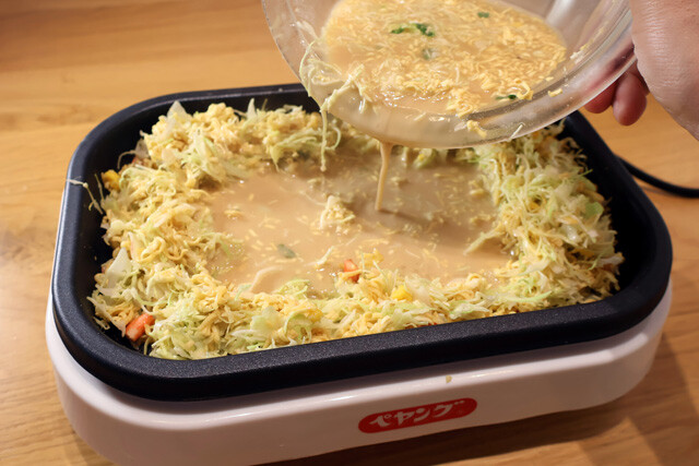 （４）焼く！　よく混ぜてから具材を先に焼いて土手を作り、生地を少しずつ流し込んで焼き上げるだけ。少し焦がした部分の香ばしさ、カリカリの麺、シーフードのダシ感が最高にウマい！