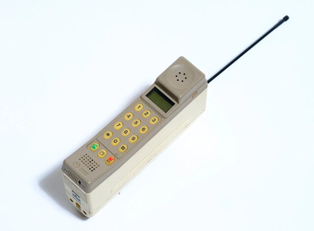 日本初となるハンディタイプ携帯電話、TZ-802型。約900g。1987年4月発売。同年、映画『私をスキーに連れてって』にも登場