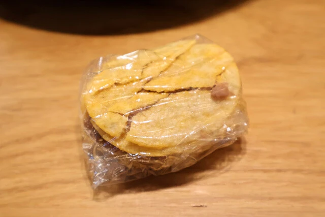 （３）包む！　そのままだとプリングルズは独特のカーブ型になっていて揚げにくいため、ラップで包んでしばらく置き、肉汁を浸透させる。柔らかくなったら優しく押し潰して形を整えよう