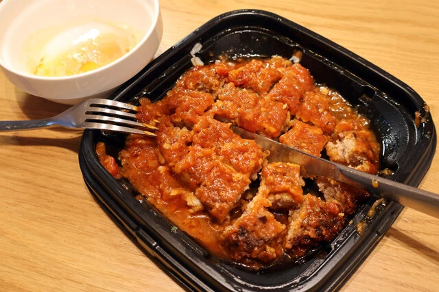 （１）切る！　松屋のうまトマハンバーグをテイクアウトし、トレーの上から半熟玉子を避難させたら、ナイフとフォークでハンバーグを細かくカットする。この時点では加熱しなくてOK