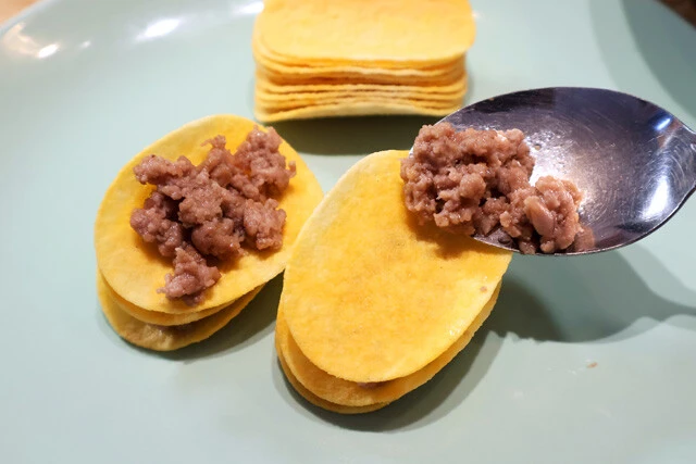 （２）挟む！　プリングルズの上に（１）をのせ、その上にまたプリングルズを重ねる。これを何重にも重ねよう。厚みが出すぎると揚げる際に崩れやすいので、サイズはひと口コロッケくらいが目安