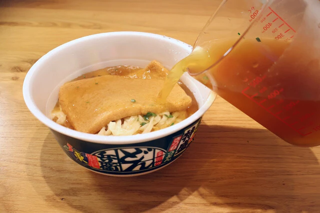 （３）スープ！　粉末スープを冷水で作ってカップに注ぐ。特盛のどん兵衛なら使用する水の量は500ミリリットル。薄めに仕上がるが、そのほうが濃厚豚骨魚介スープとの一体感が出る。全量入れること！