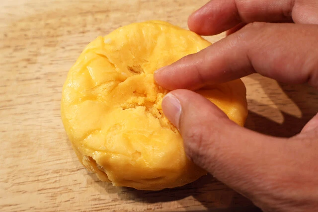 （３）つまむ！　ピザまんの皮の穴周辺を水で軽く湿らせ、餃子の皮を閉じるように指先でつまみ、穴を閉じる。完全に閉じられなくてもどうにかなる。力を入れすぎると逆に穴が開くので要注意！