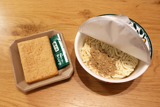 （１）開封！　どん兵衛きつねうどん（東日本版）を開封し、お揚げを取り除いたら粉末スープを入れる。余ったお揚げはそのまま食べても、いなりずしにしても、うどんに足してもOK！