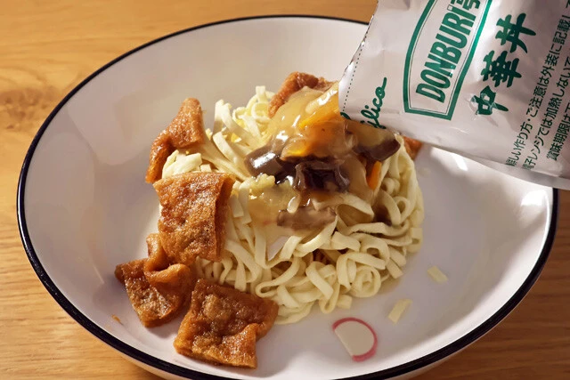 （３）かける！　どん兵衛の麺とかまぼこを食器に移し、（２）を麺の上にのせたら、温めたレトルト中華丼の具をかければ完成。麺をあんに浸しながらほぐしつつ、豪快にかぶりついて食べよう